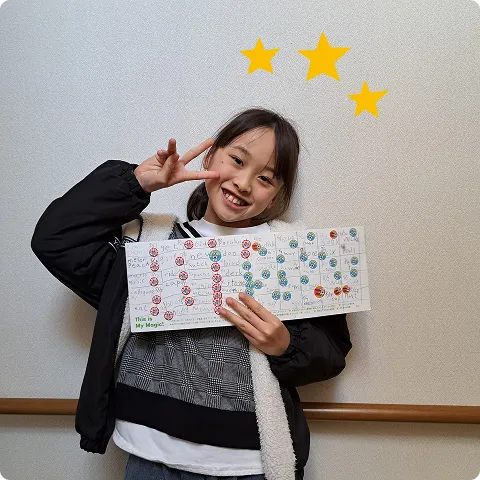 MAGIC BOOKを持ってピースしている難波さんの写真