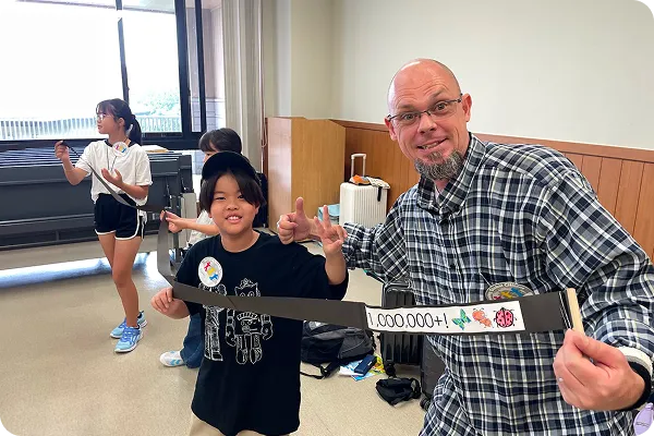 講師と生徒が笑顔でピースをしている写真