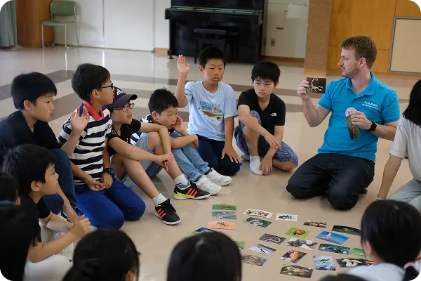 講師が写真カードを使って子どもたちにレッスンしている写真