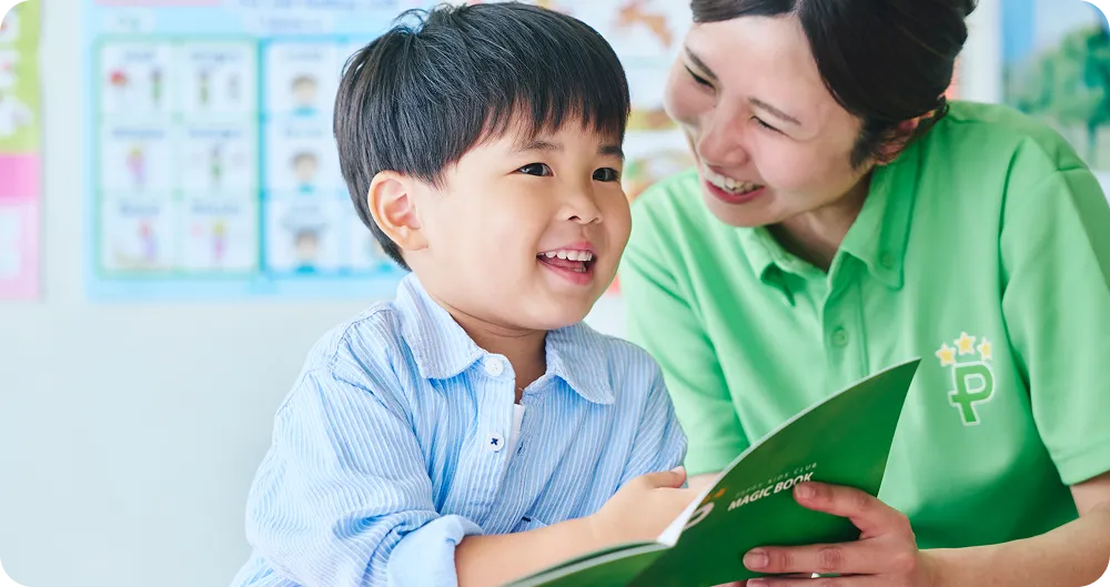 講師が男の子と一緒にMAGIC BOOKを使って学習成果を確認している写真