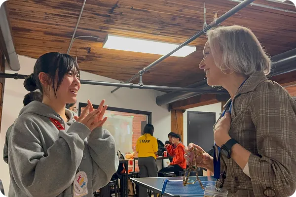 笑顔で外国人講師と会話をする女の子の写真