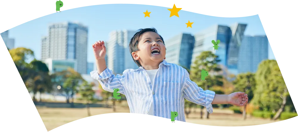 公園で両手を上げて大きな笑顔を見せる男の子の写真