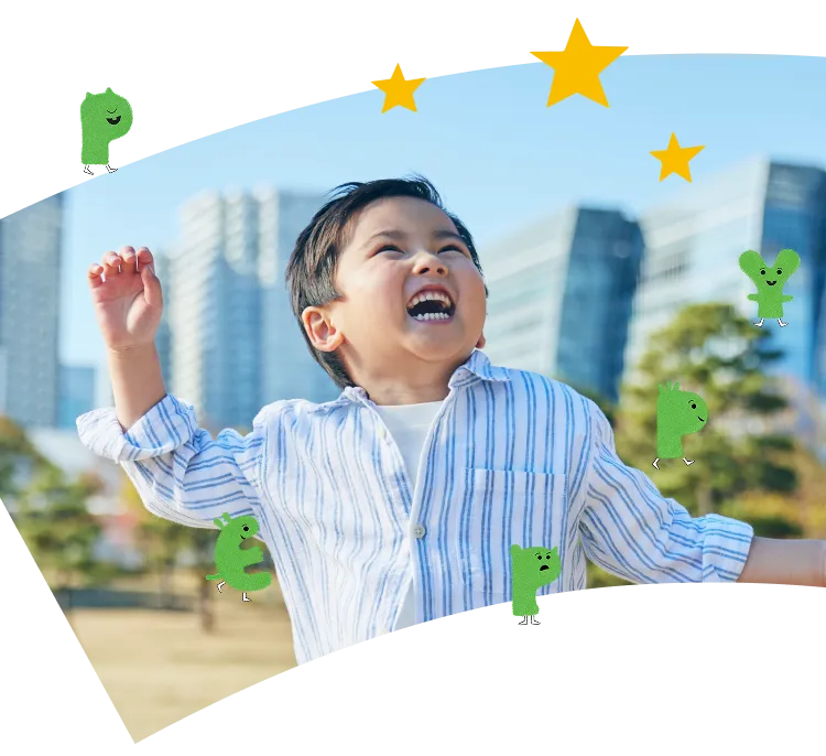 公園で両手を上げて大きな笑顔を見せる男の子の写真